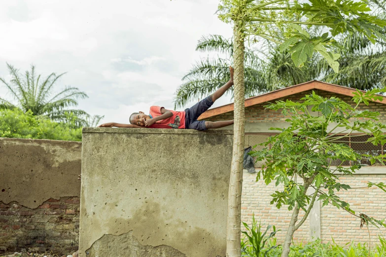 a girl laying on top of a concrete building