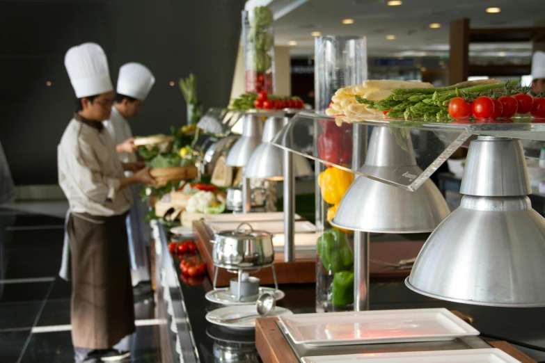 some people preparing food on plates in a kitchen