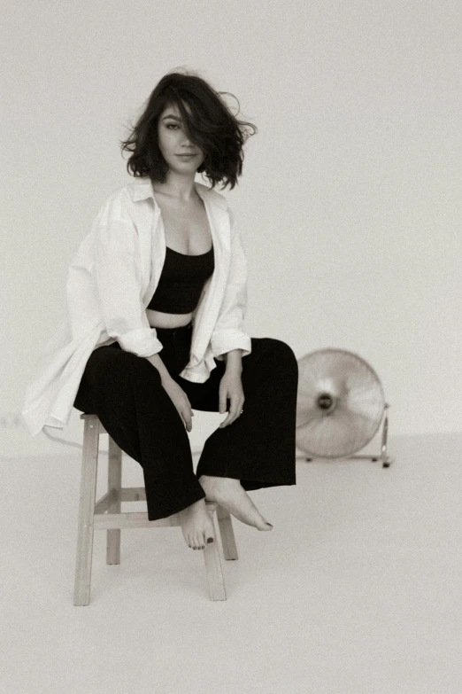 a woman sitting on top of a wooden stool