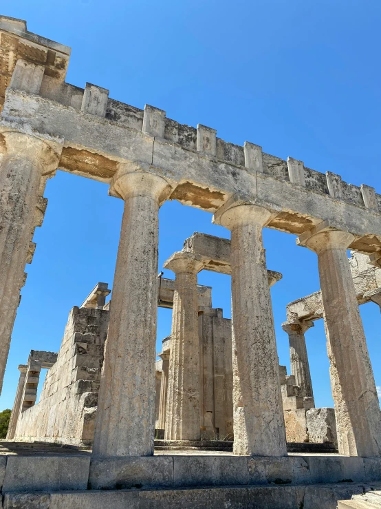 a row of roman columns against a bright blue sky