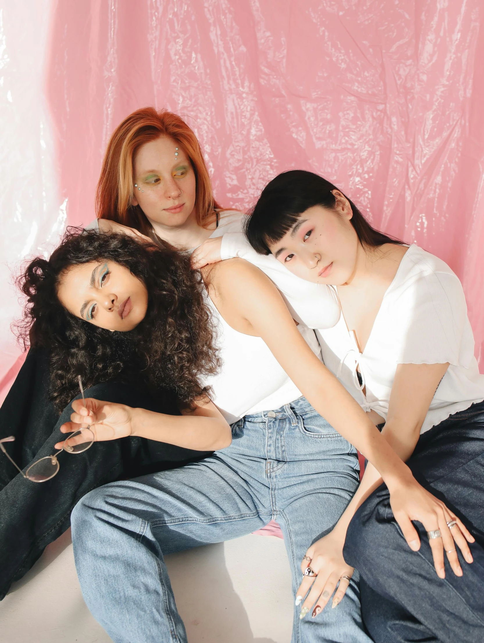 three young women posing in front of pink backdrop