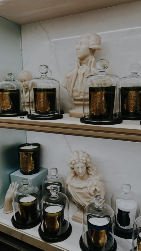 a group of different candles sitting on a shelf