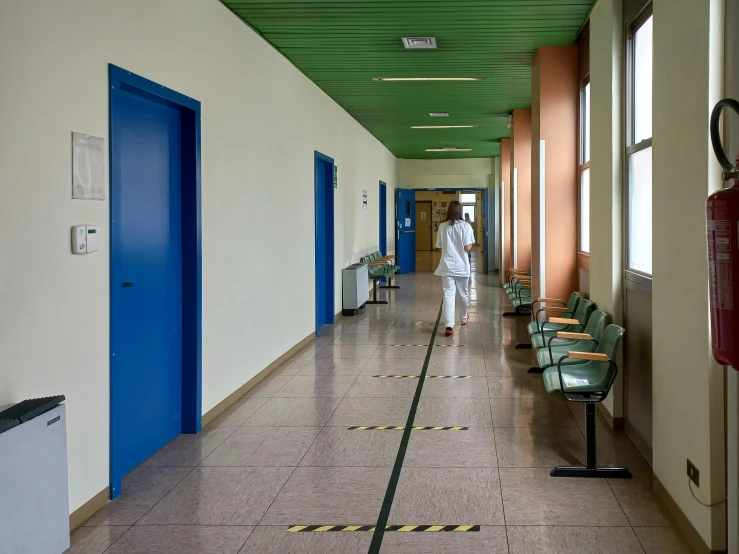 a person in white is walking down the hallway