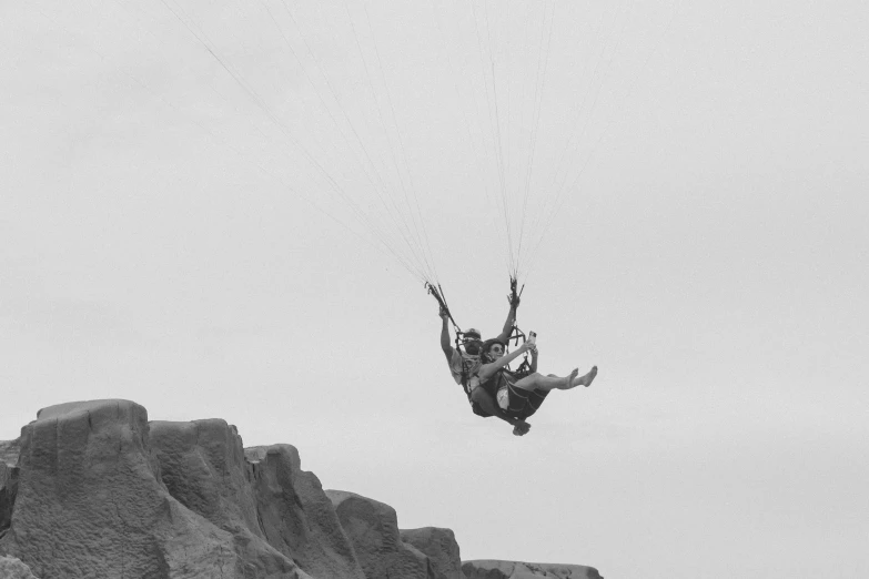 man in water suit on paragliding over desert terrain