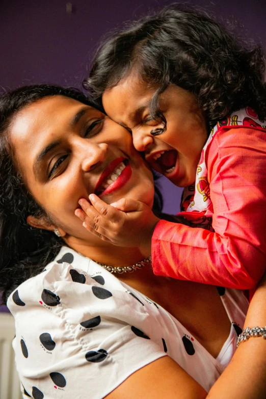 a woman holding a child who has a toothbrush in her mouth