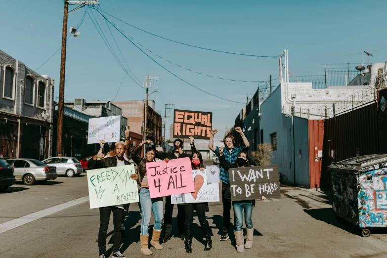 several protesters holding signs on a city street