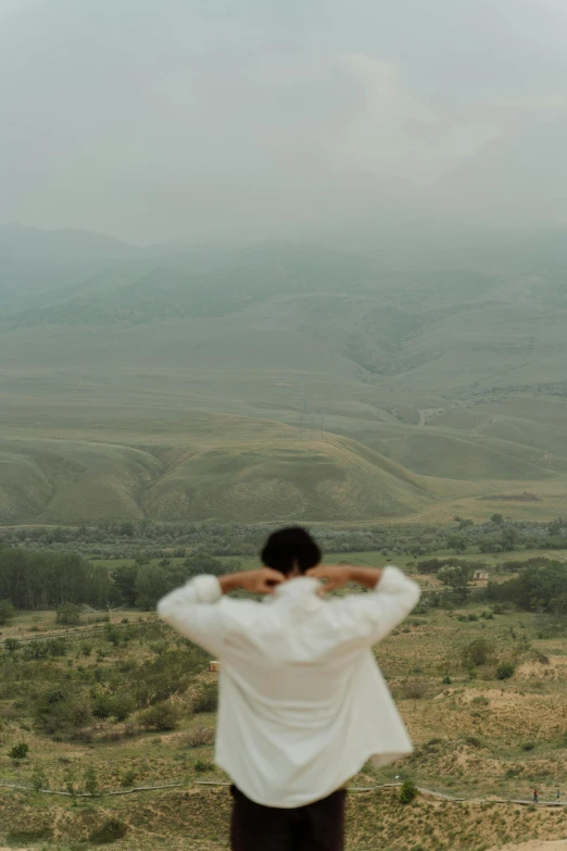 a person on a hill with mountains in the background