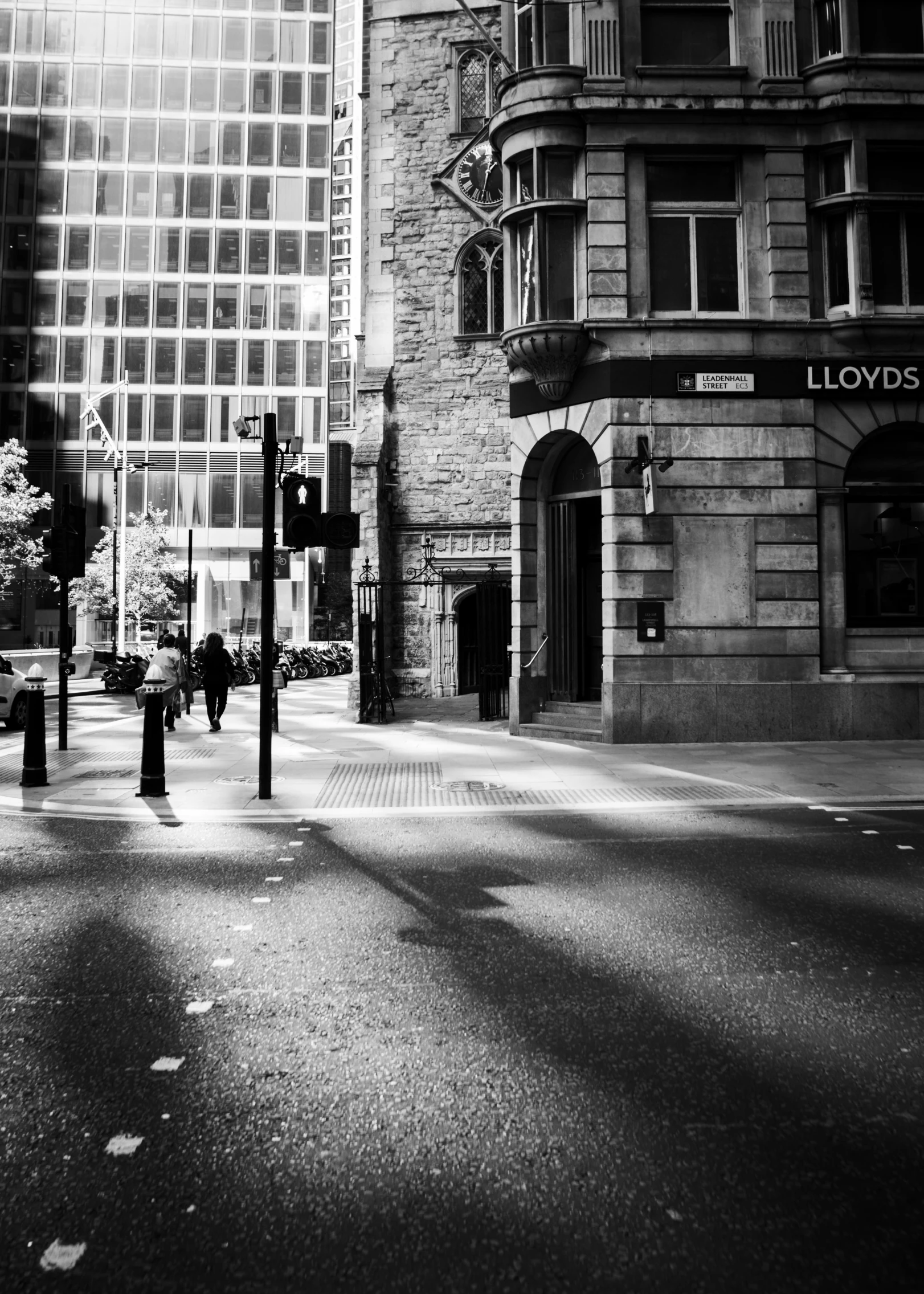 a city street intersection, with pedestrians and cars in the distance