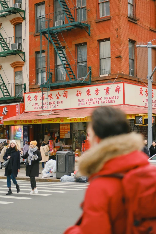 a woman is crossing a busy street in front of an asian restaurant