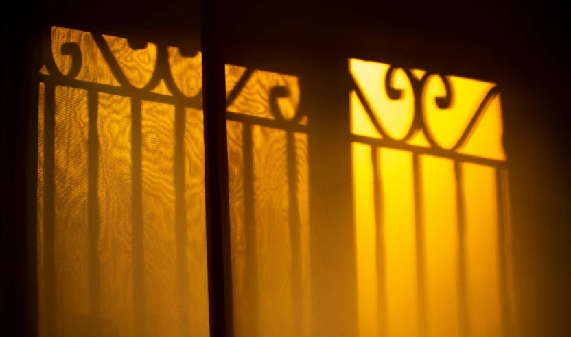 the shadow of a curtain and some yellow curtains