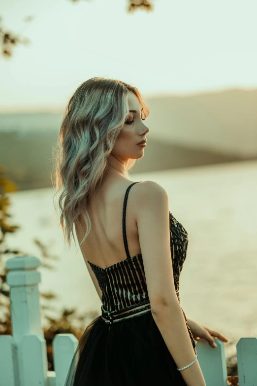 a young woman standing in front of a body of water