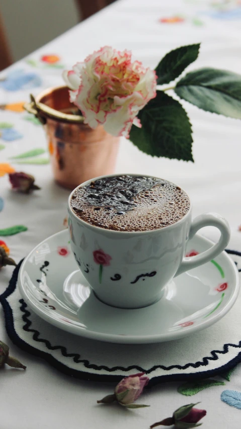 a cup on a saucer with a flower in the middle