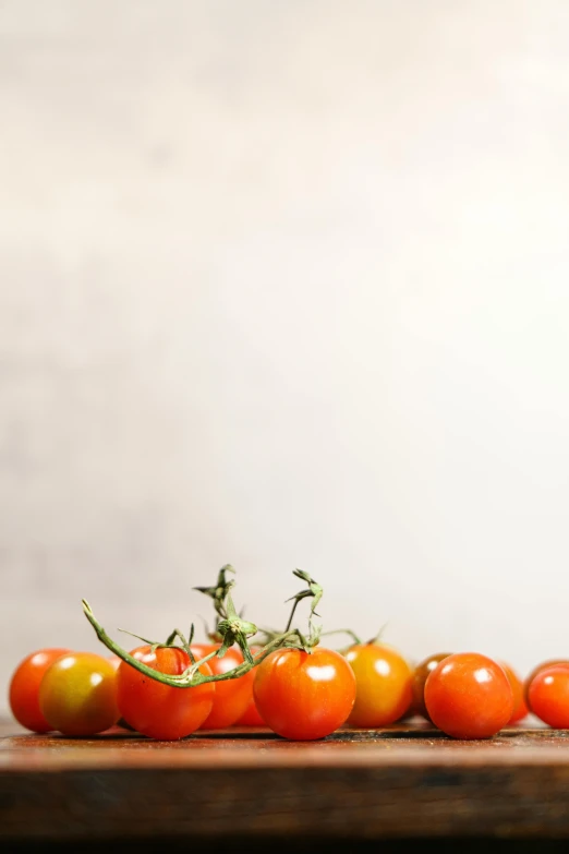 a group of tomatoes sitting on top of a wooden table