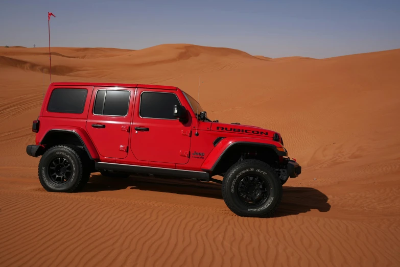 red jeep on the desert in the middle of desert