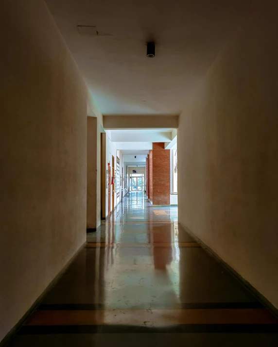 an open hallway with yellow doors and tiled floor