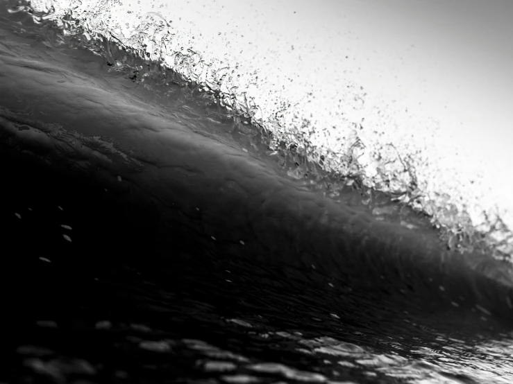 someone surfing on an ocean wave in black and white