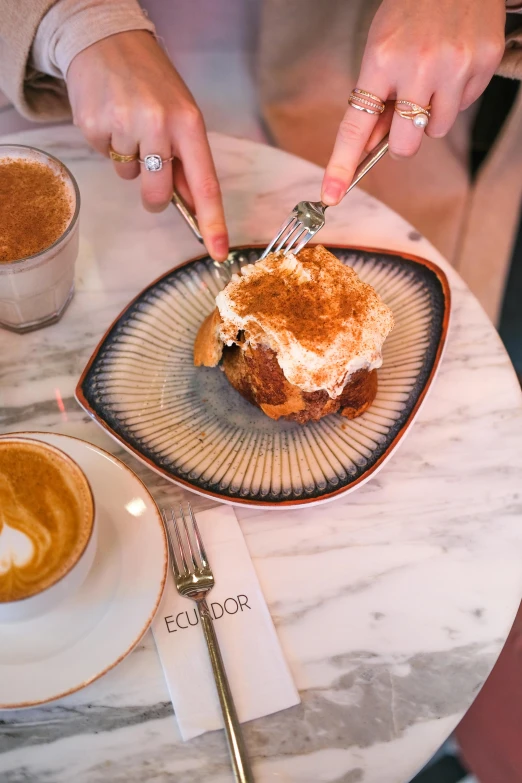 a person with a knife and fork  into food on a plate