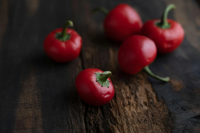 four ripe red tomatoes and one green stalk