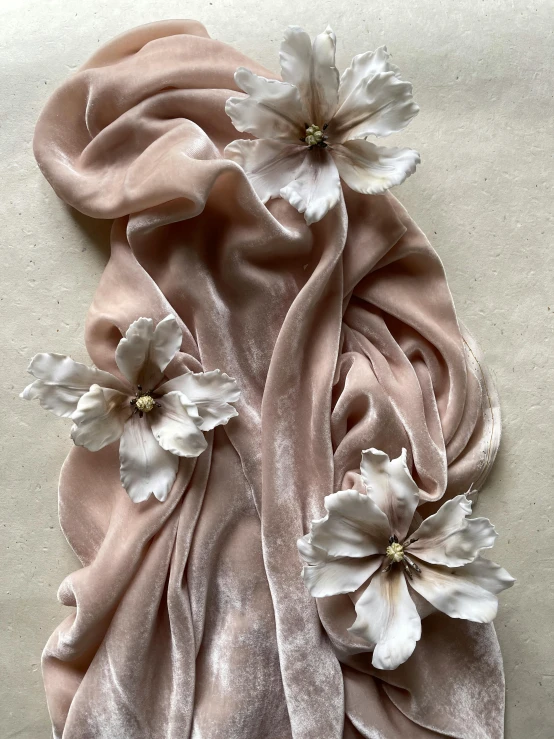 the pink and white flower petals are covering a pink scarf