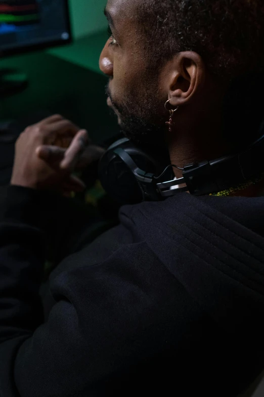 a black man wearing earring and staring away