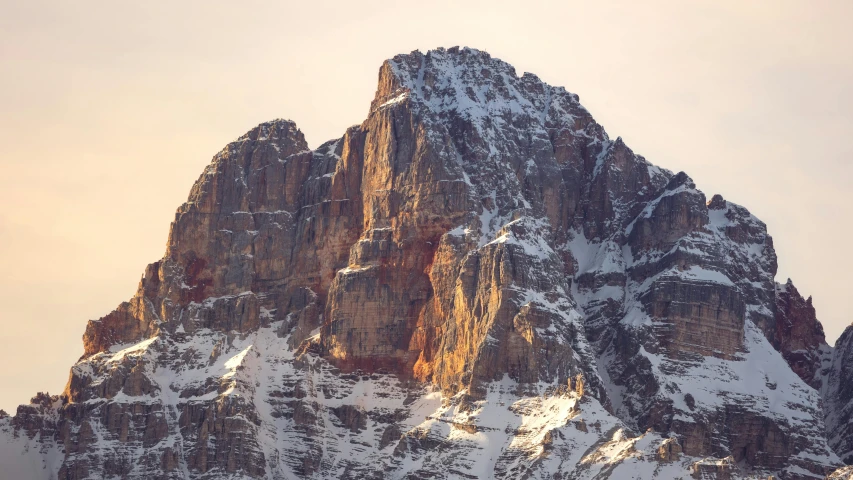 the peak of a mountain that has a very snow laden top