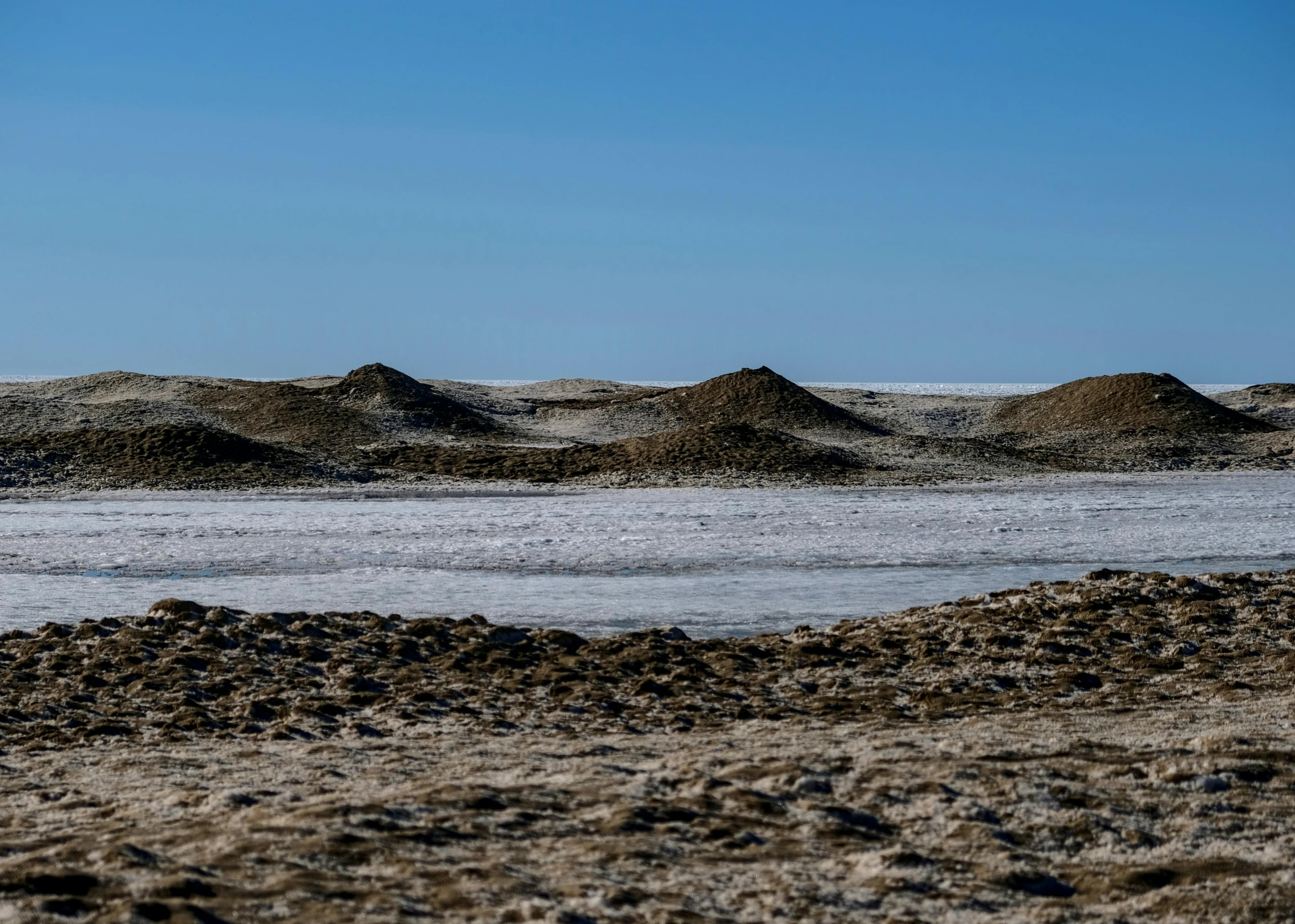 a beach area with rocks and gravel on the shore