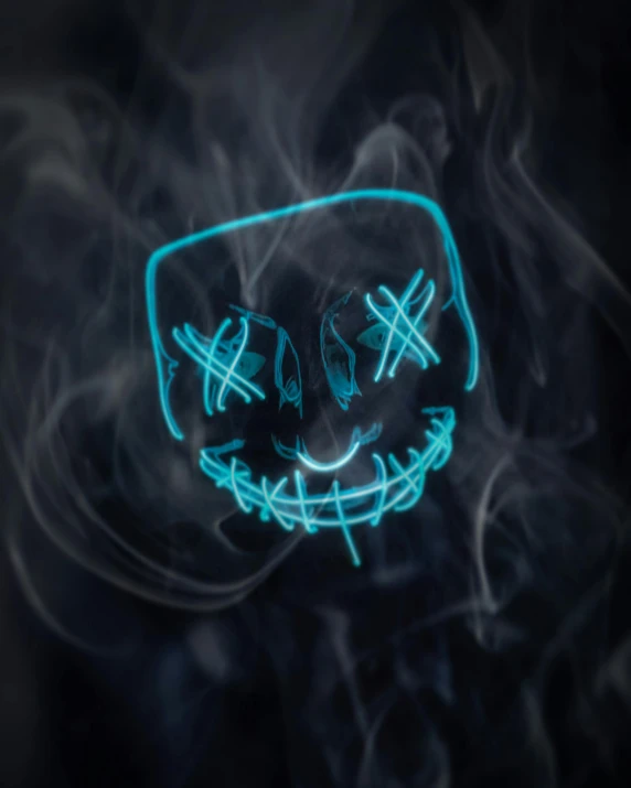a mask with blue neon lights is floating in the smoke