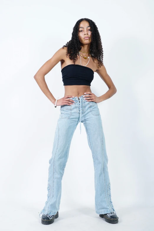 a woman standing wearing cropped and jean pants