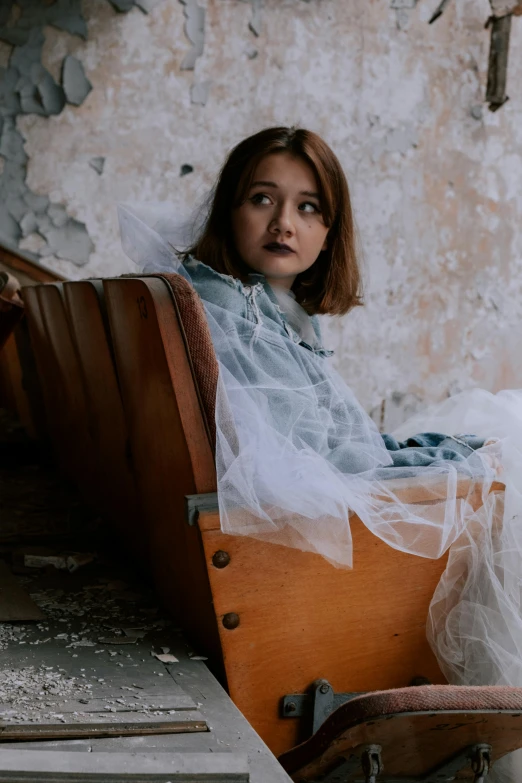 a woman sitting in a chair wearing a veil