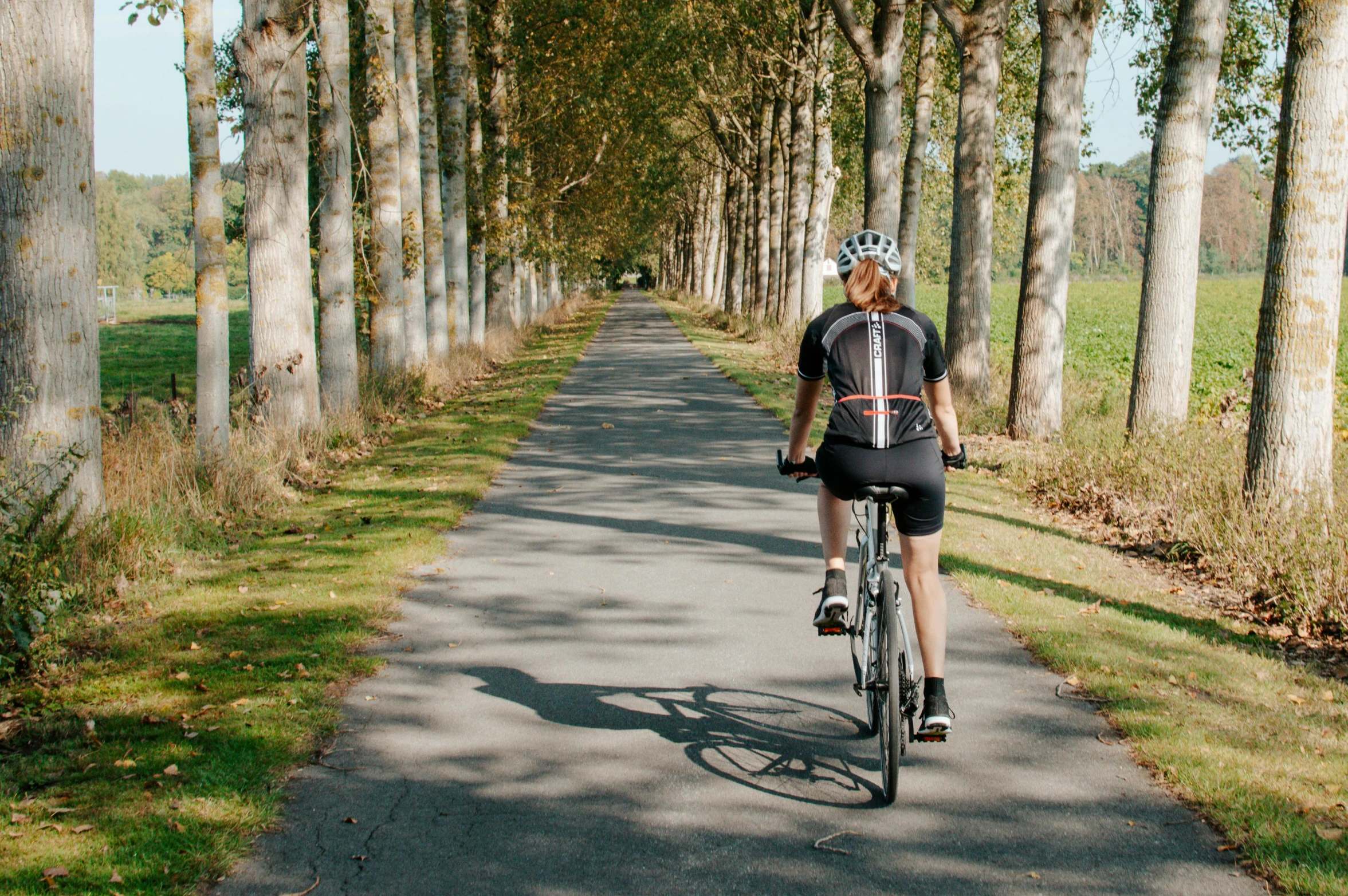 a woman on a bicycle riding down the street