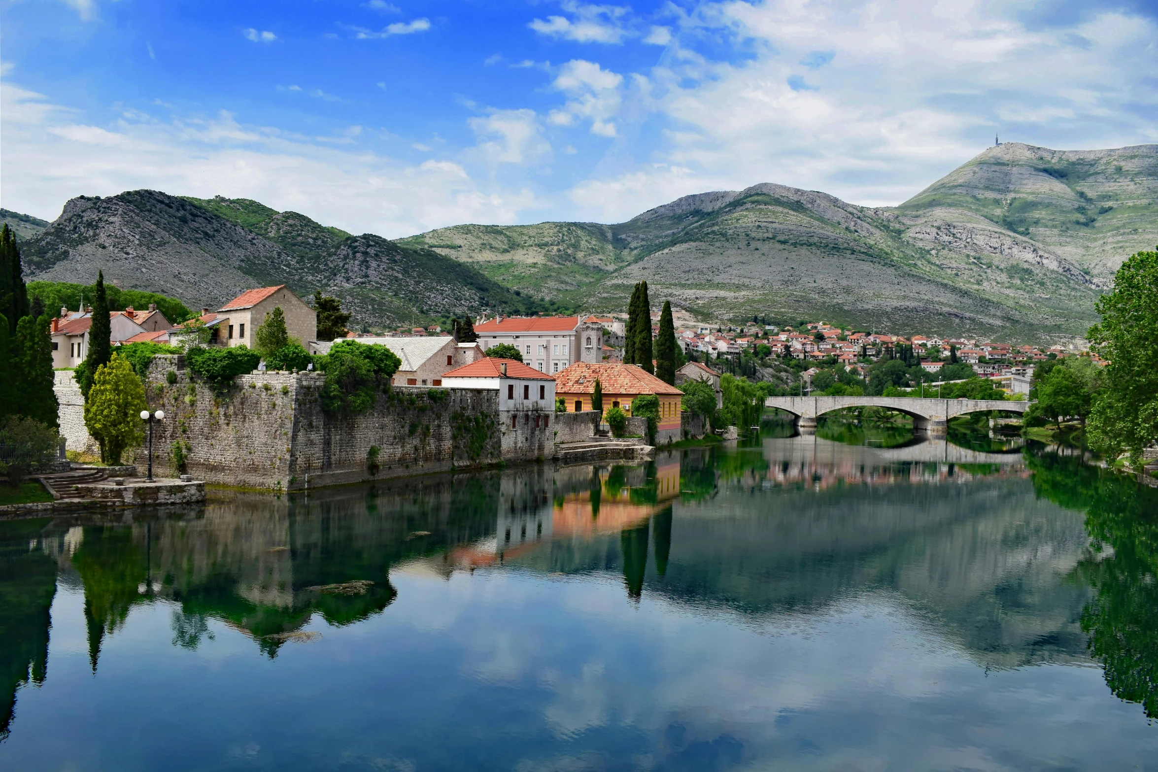 a waterway with water, mountains and houses