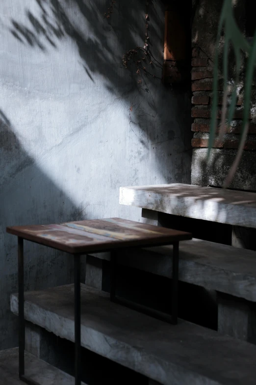 two tables on top of steps with a wall behind them