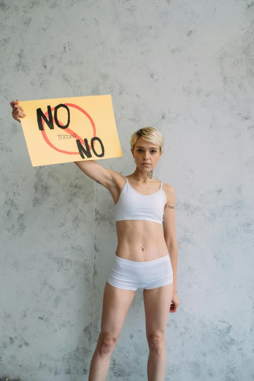 a woman holds a no on sign over her hips