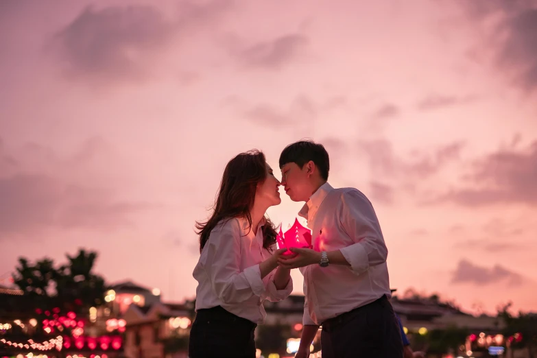 a woman and man are kissing by a lake