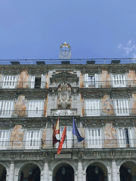 the facade of an old building is decorated with architectural details and many flags