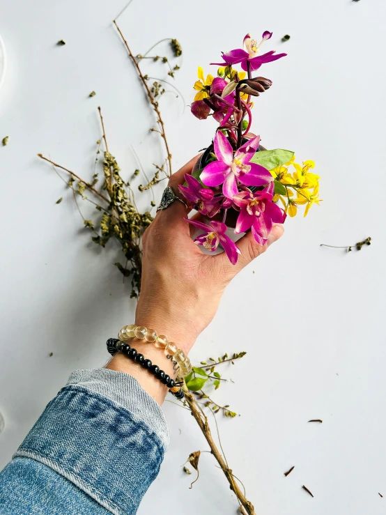 the person is holding some flowers in his hand