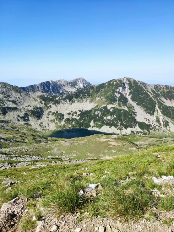 the grassy field is in front of the mountain range