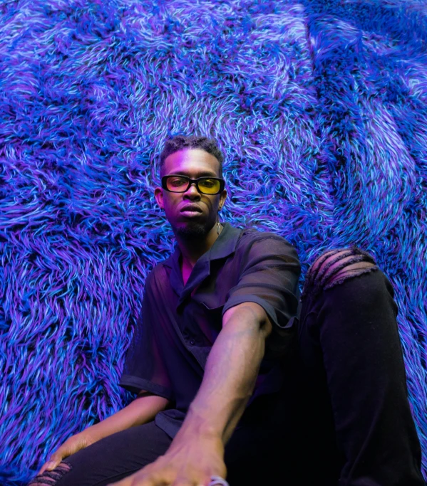 a man with eye glasses lying on a carpet