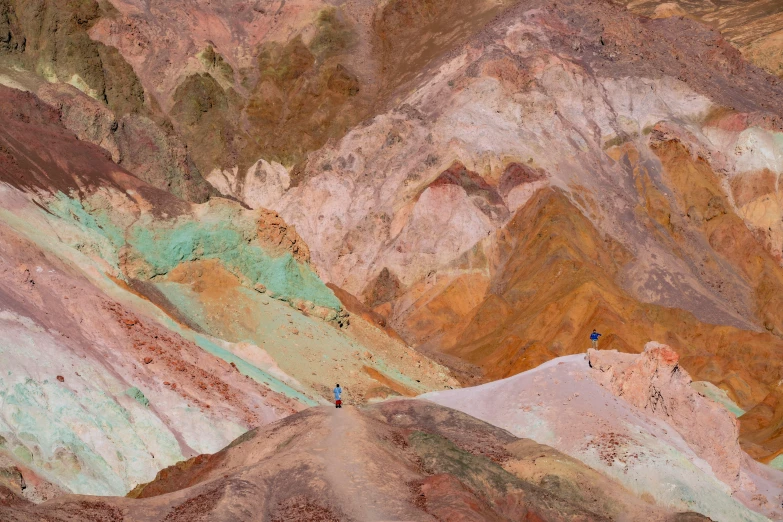 a colorful mountain with small blue birds in the sky