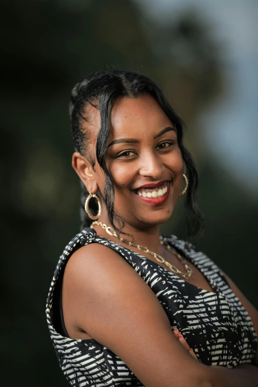 a woman smiling with her hair in a bun