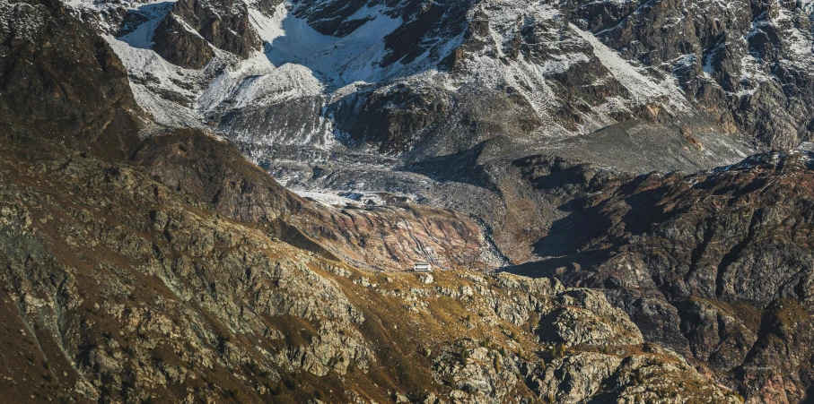 a po taken from the air of a rocky mountain with white snow on the top