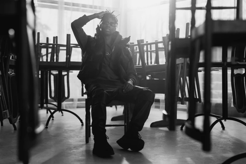 black and white po of man sitting on chair in a room