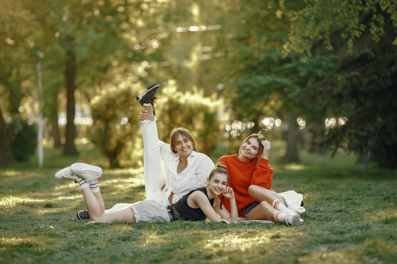 two women and two s laying on grass