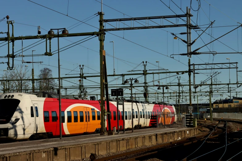 a train on the track with lots of power lines