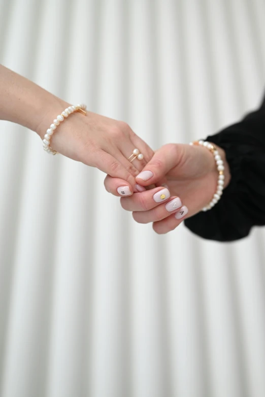 two people holding hands in white and black