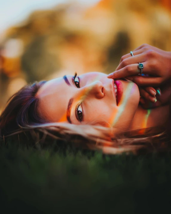 woman laying on grass with multicolored hair and nails
