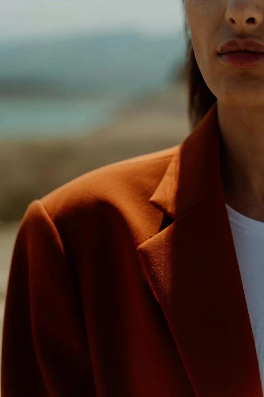 close up of person with red blazer on holding cellphone