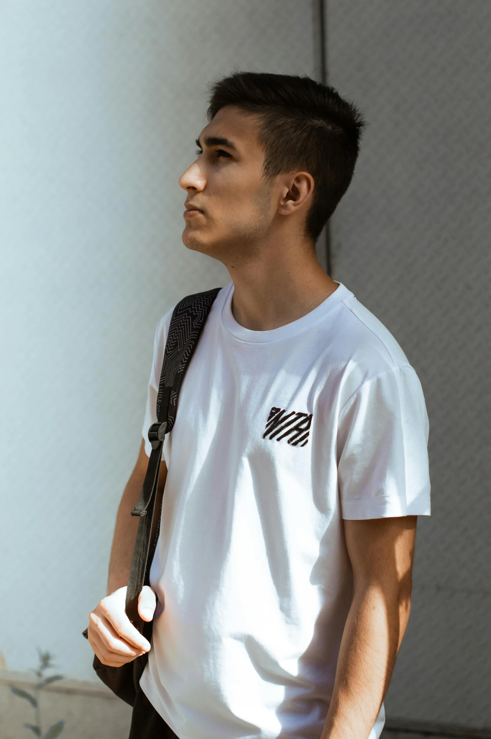 a man with a white t - shirt and black bag