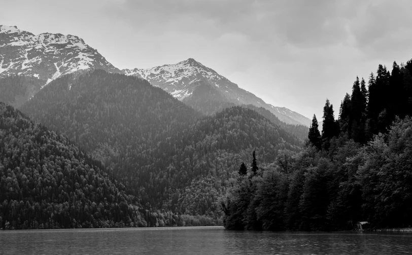 the mountains in a black and white po are near the water