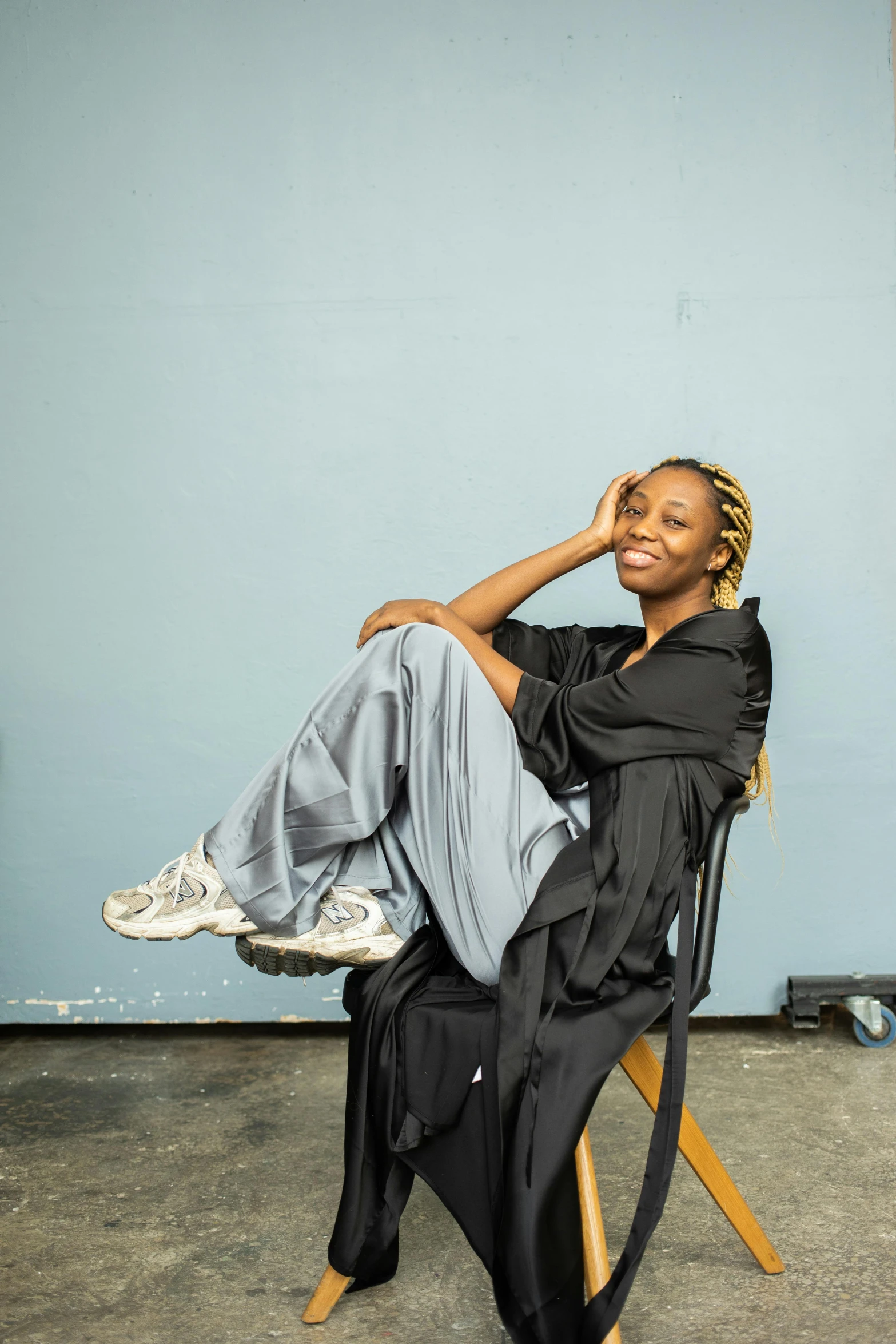 a woman sitting in a chair, on the floor of a room